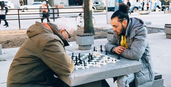 Joven y mayor jugando al ajedrez